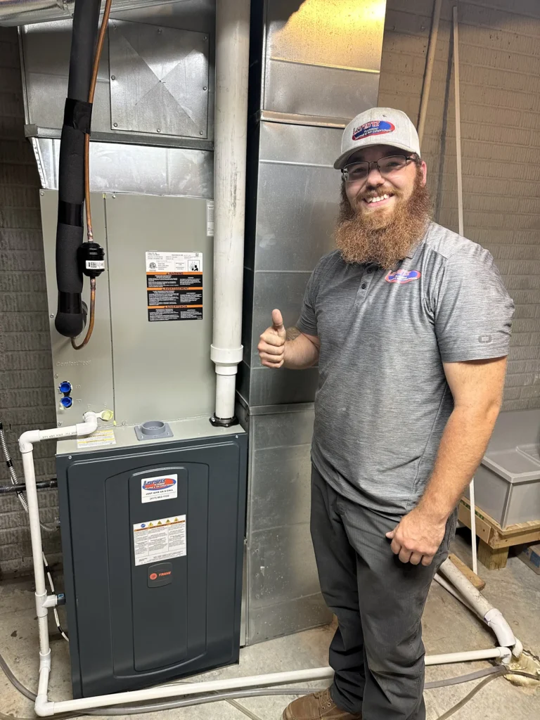 team member next to furnace-lorenz plumbing heating and air-springfield