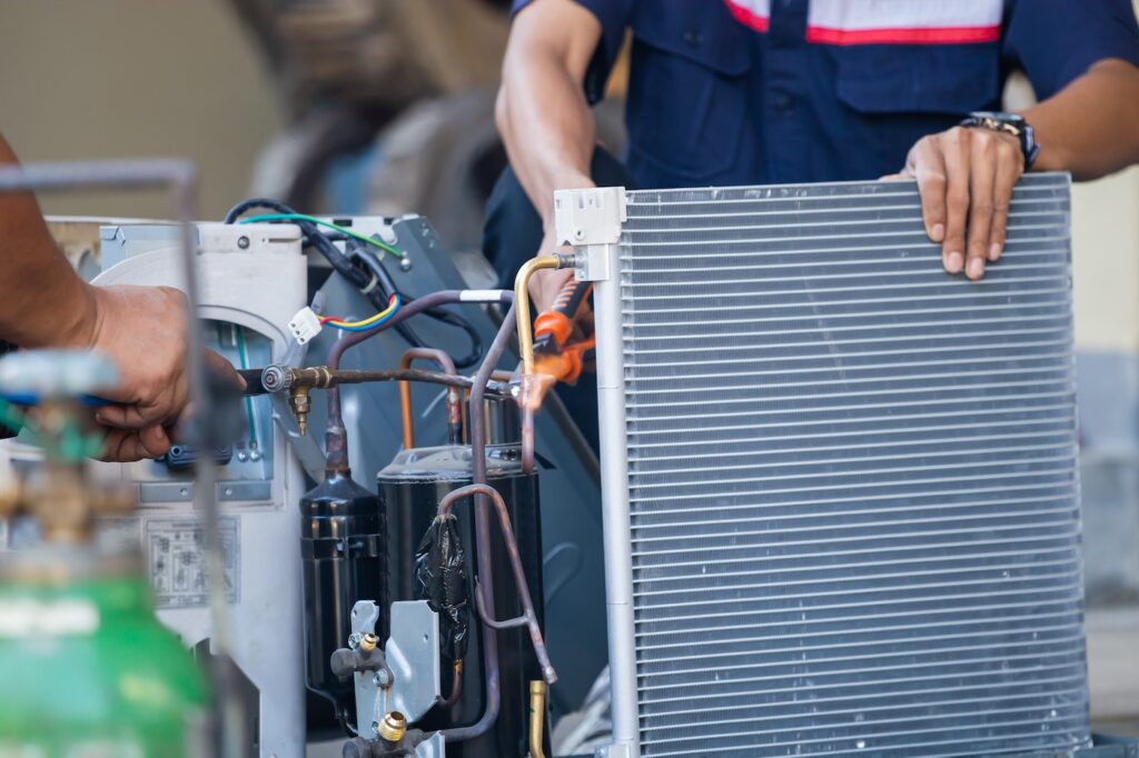 Air Conditioning Repair team use fuel gases and oxygen to weld or cut metals, Oxy-fuel welding and oxy-fuel cutting processes, repairman on the floor fixing air conditioning system