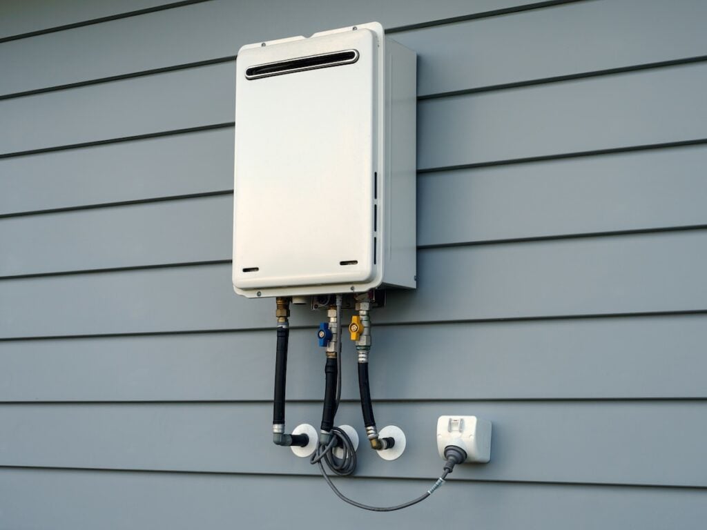 Modern external continuous flow gas water heater mounted on house wall