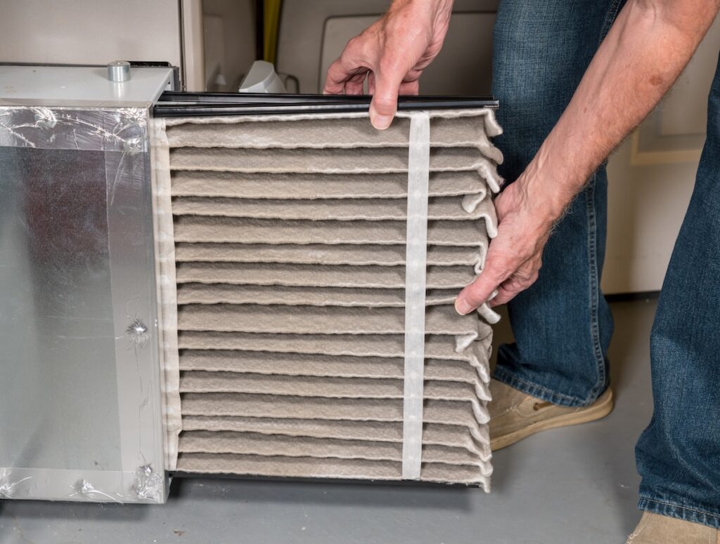 changing a folded dirty air filter in the HVAC furnace system