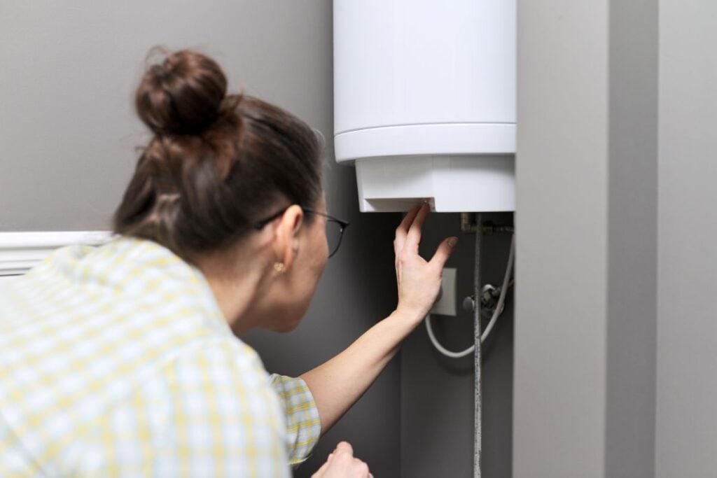 boiler vs furnace young woman adjusting water temperature inside house