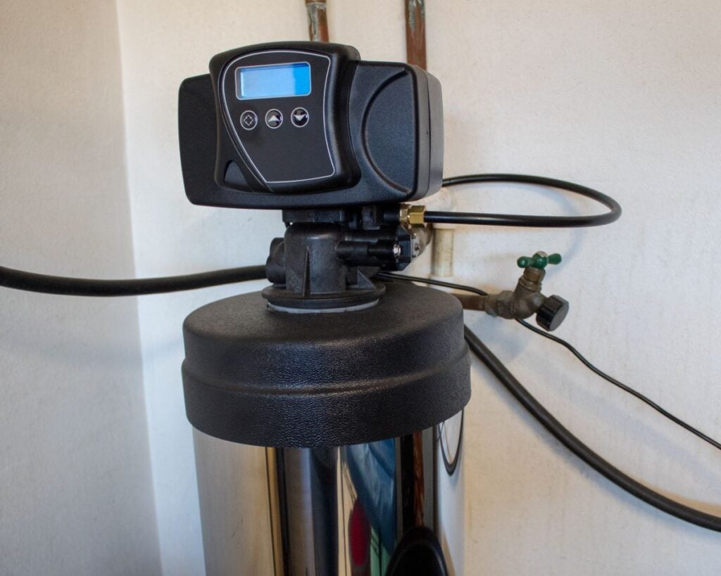 salt free water softener black filter against wall connected to water system