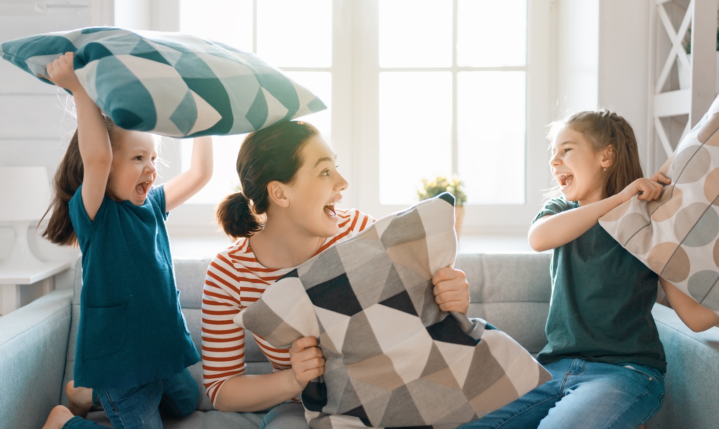 candid-family-cozy-inside-having-a-pillow-fight